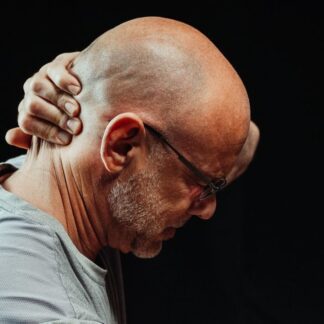 Hombre mayor sujetándose el cuello con la mano por dolor cervical