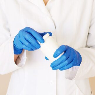 Profesional sanitario con bata blanca y guantes de nitrilo azules