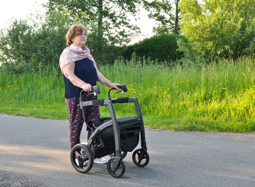 Mujer mayor caminando por la calle con un andador rollator