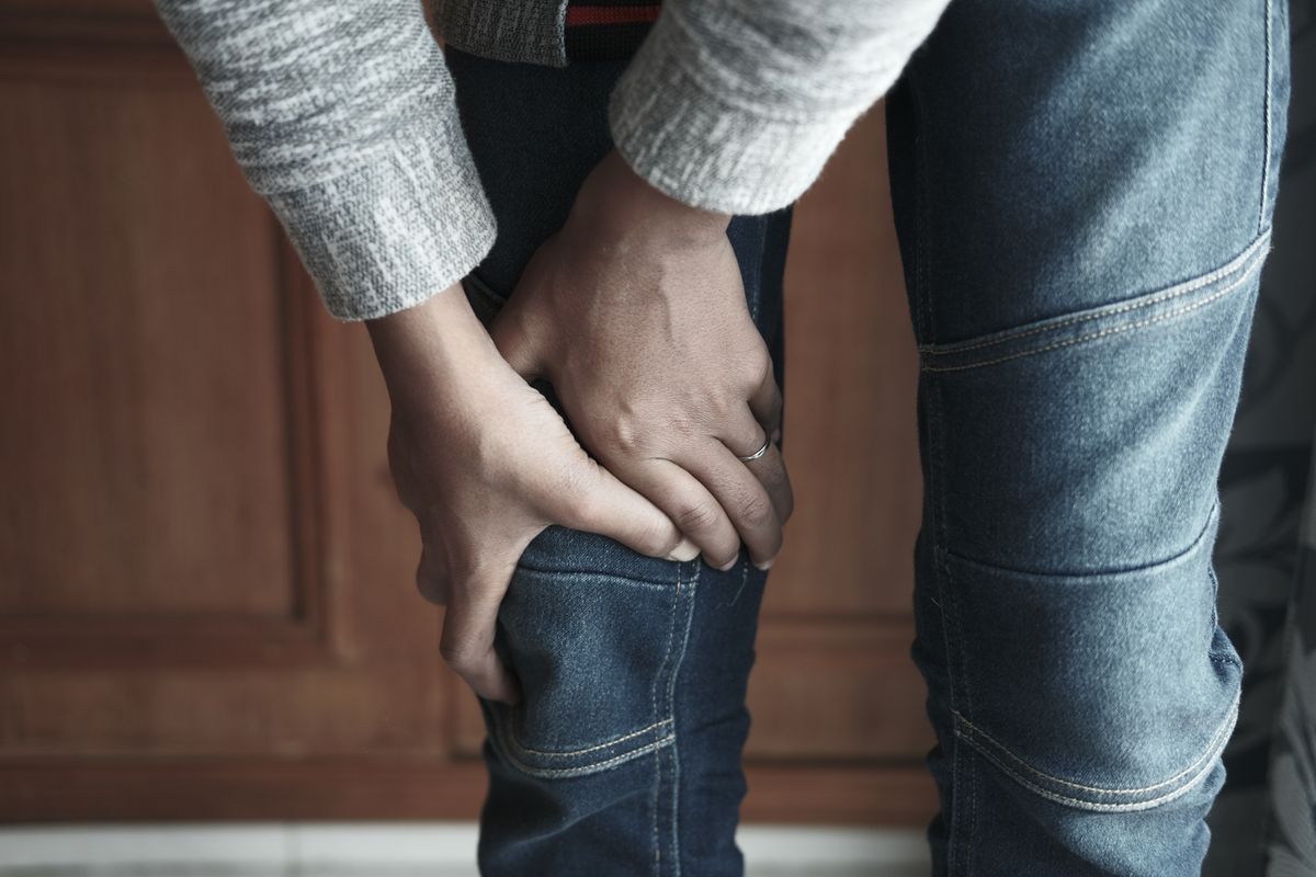 Primer plano de una persona sujetándose la rodilla con las manos